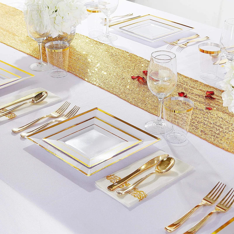 A close-up of a gold plastic dinnerware set for a formal table setting with glassware and gold accents.