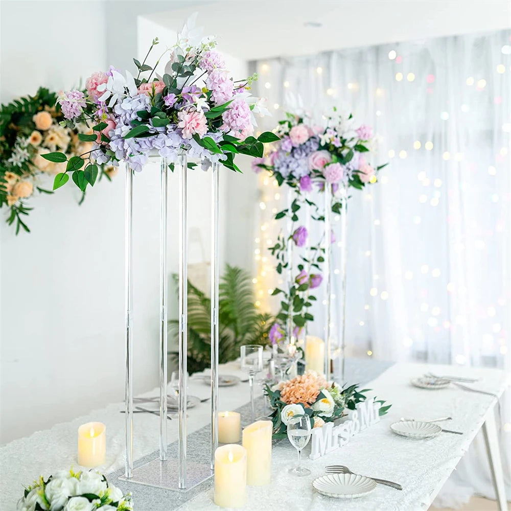 Vases centraux en acrylique élégants avec des arrangements floraux sur une table décorée pour une fête.