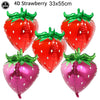 Five red and pink strawberry-shaped foil balloons for party decorations