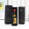 Three black gift boxes with gold foil accents and a red rose inside, presented on a white surface.