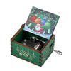 A vintage hand-cranked wooden music box with a green wooden case and a Christmas-themed lid.