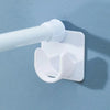 White self-adhesive curtain rod brackets with adjustable clips mounted on a light blue wall.