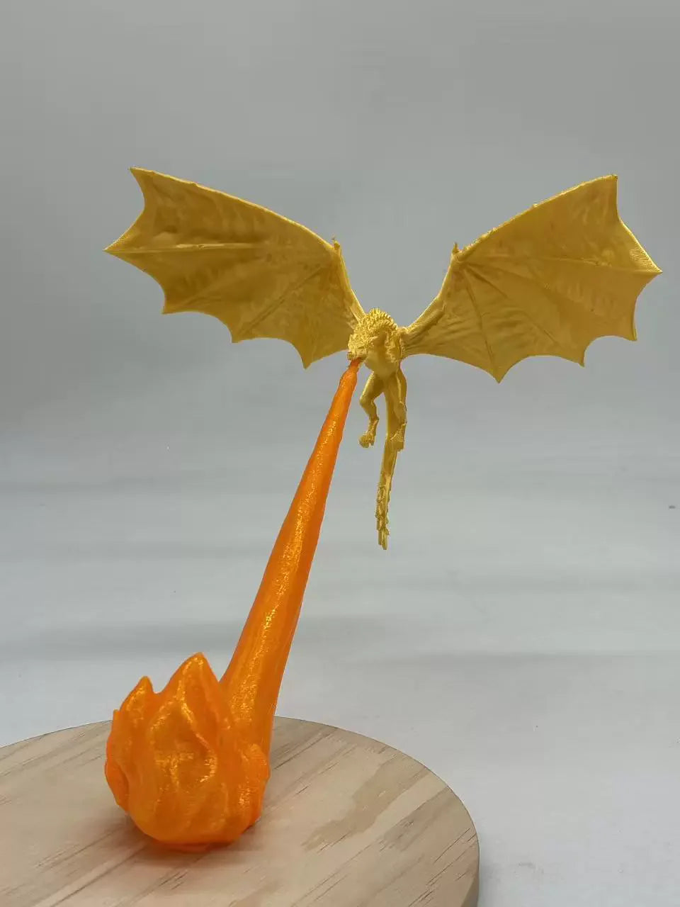 A golden dragon flame light fixture with translucent orange fire effect mounted on a wooden surface.