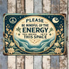 Vintage metal wall sign with a dark teal background featuring a peace symbol, moon, and text reminding viewers to be mindful 