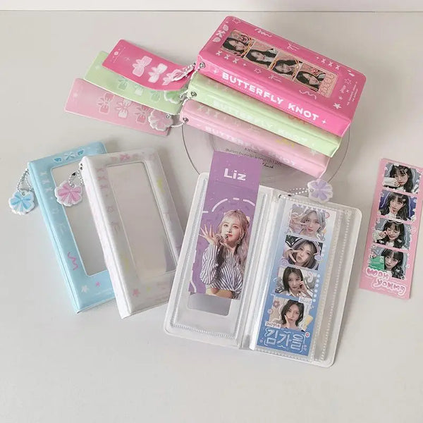 A collection of pink and green photo booth albums and a clear photo frame are displayed on a white surface.
