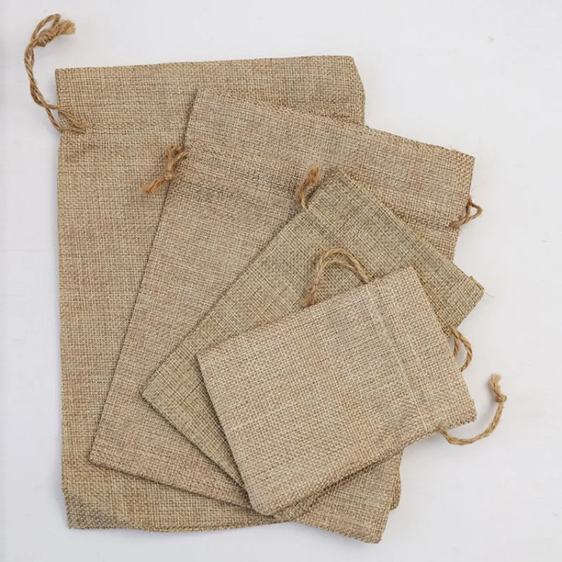 A stack of natural burlap drawstring bags in beige color.