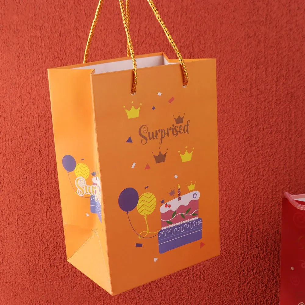 An orange gift box with gold string, featuring a surprised theme and a cake design.