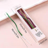 A package of rainbow colored curved metallic birthday cake candles with measuring lines.