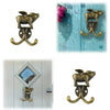 A set of decorative brass metal wall hooks shaped like a ram or goat, shown in various contexts.