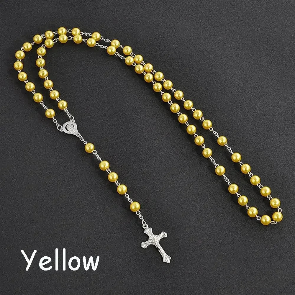 A yellow bead rosary necklace featuring a silver cross and a small pendant.