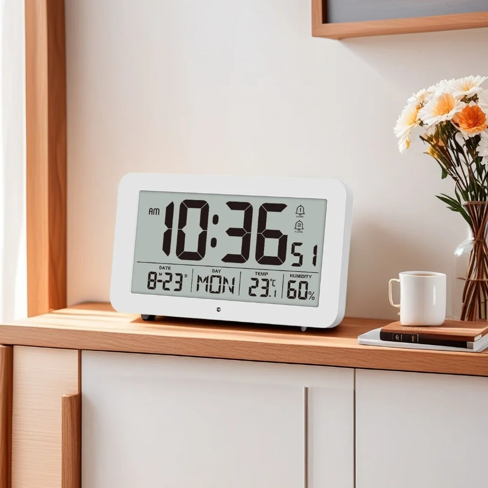 A white digital wall clock displaying 10:36 AM, temperature, and humidity, sitting on a wooden shelf.