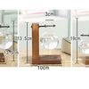 A wooden clamp stand holds a glass vase with a plant, demonstrating various heights and measurements.