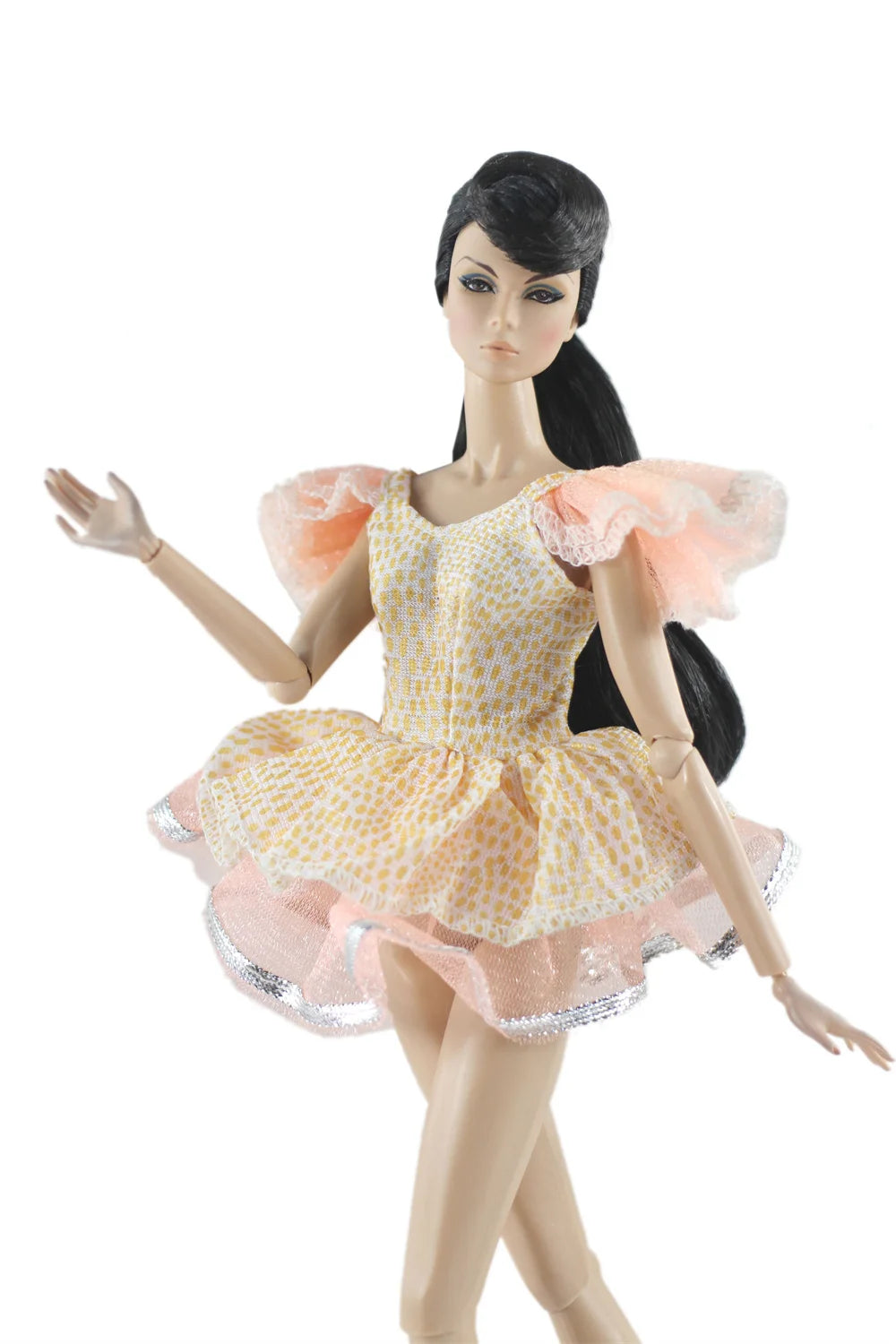 A handmade doll dress gown featuring yellow and pink floral patterns with ruffled sleeves and glitter trim.