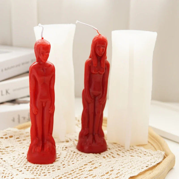 Three red silicone molds shaped like realistic human figures used for candle and resin crafting