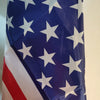 A close-up of the American flag waving against a light background.