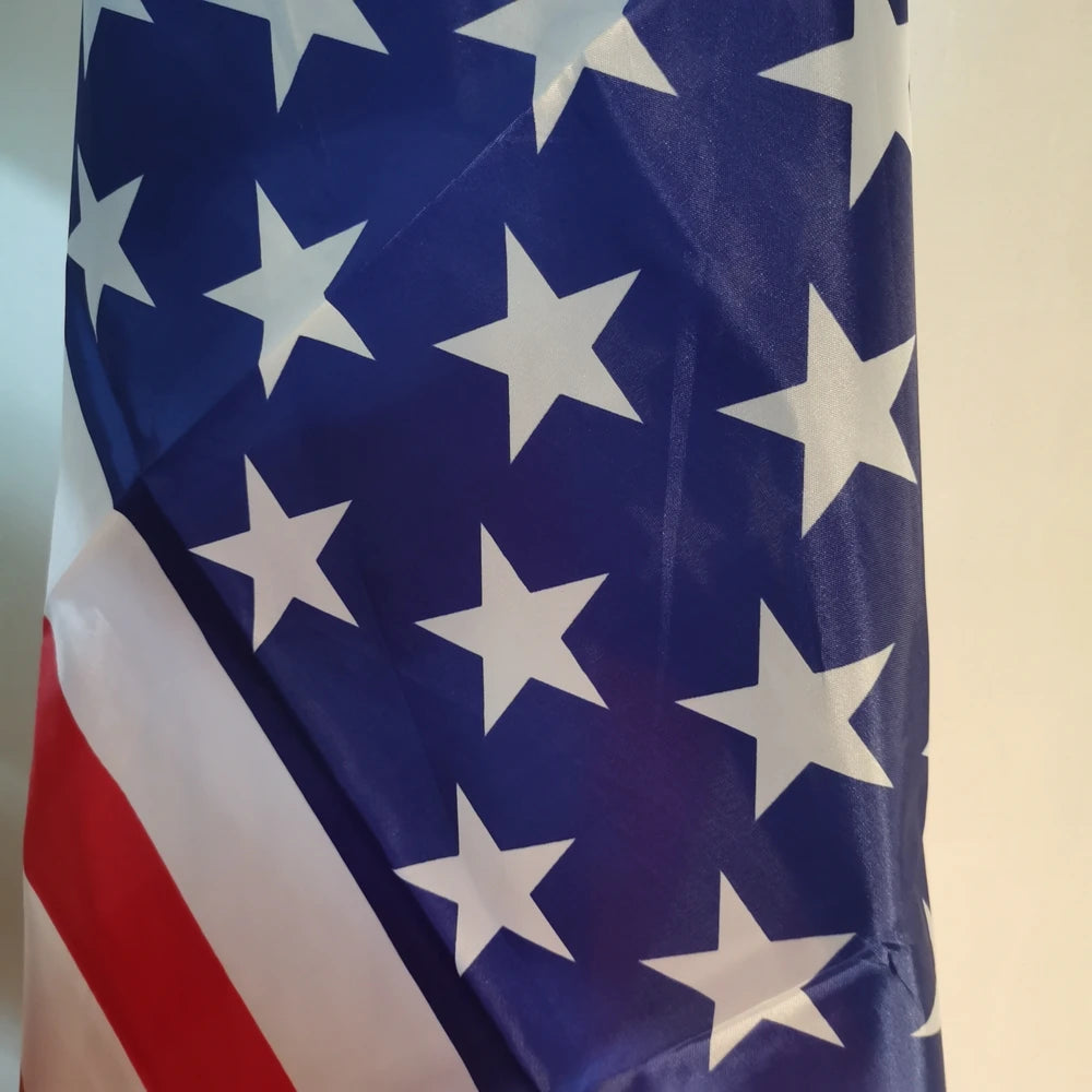 A close-up of the American flag waving against a light background.
