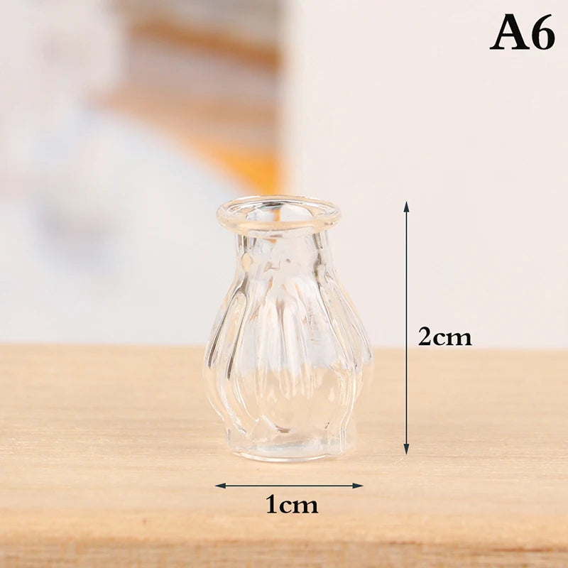 A clear glass miniature vase and bottle set displayed on a wooden surface.