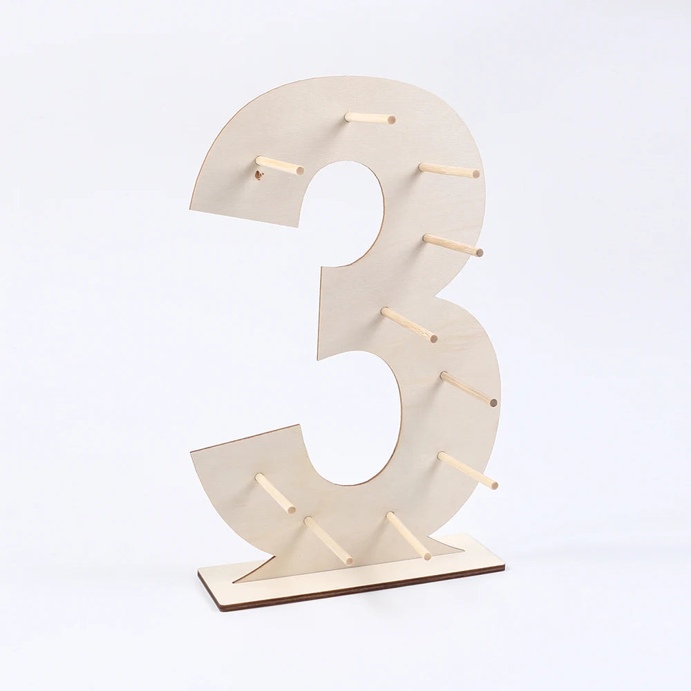 A light wood number display stand shaped like the number three, used for desserts.