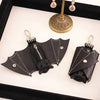 Black leather bat wallet keychain with zipper coin purse displayed in a black box.