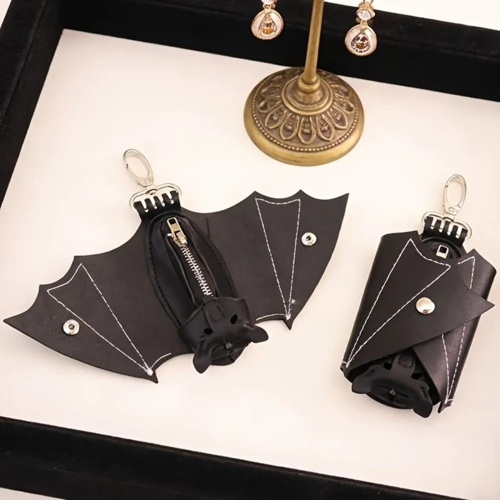 Black leather bat wallet keychain with zipper coin purse displayed in a black box.