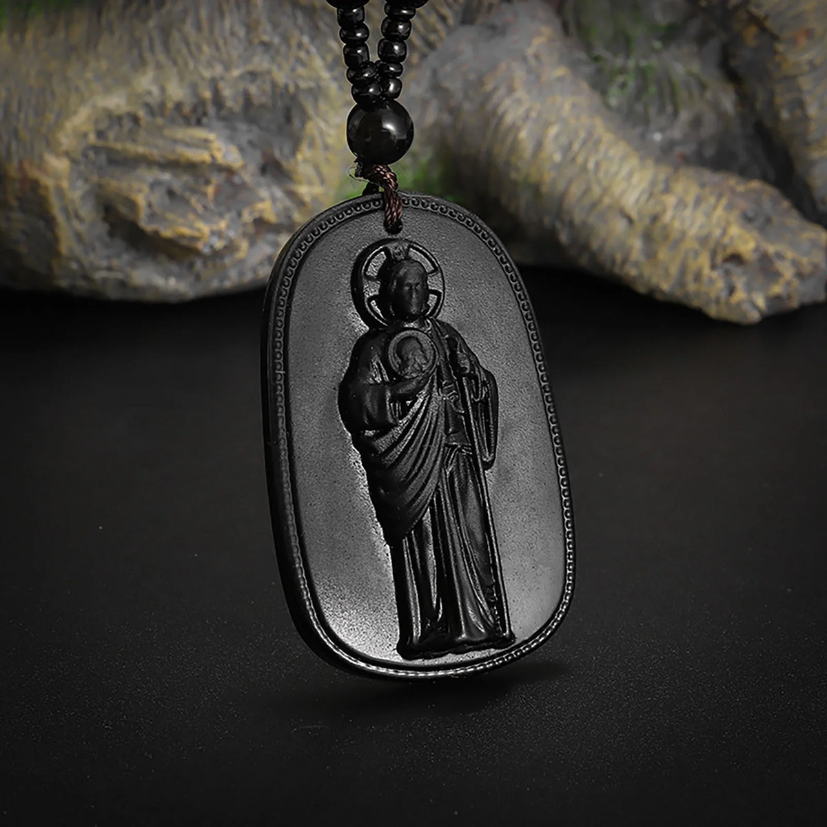 A black obsidian pendant necklace featuring a relief carving of Saint Jude Thaddeus.
