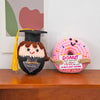 Handmade crochet potato doll with a graduation cap and inspirational tag on a wooden surface.