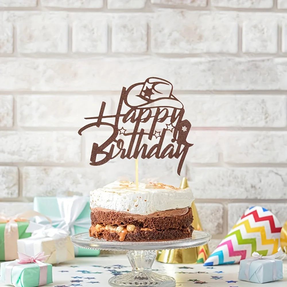 A brown glitter birthday cake topper featuring a cowboy hat and stars on a white cake.