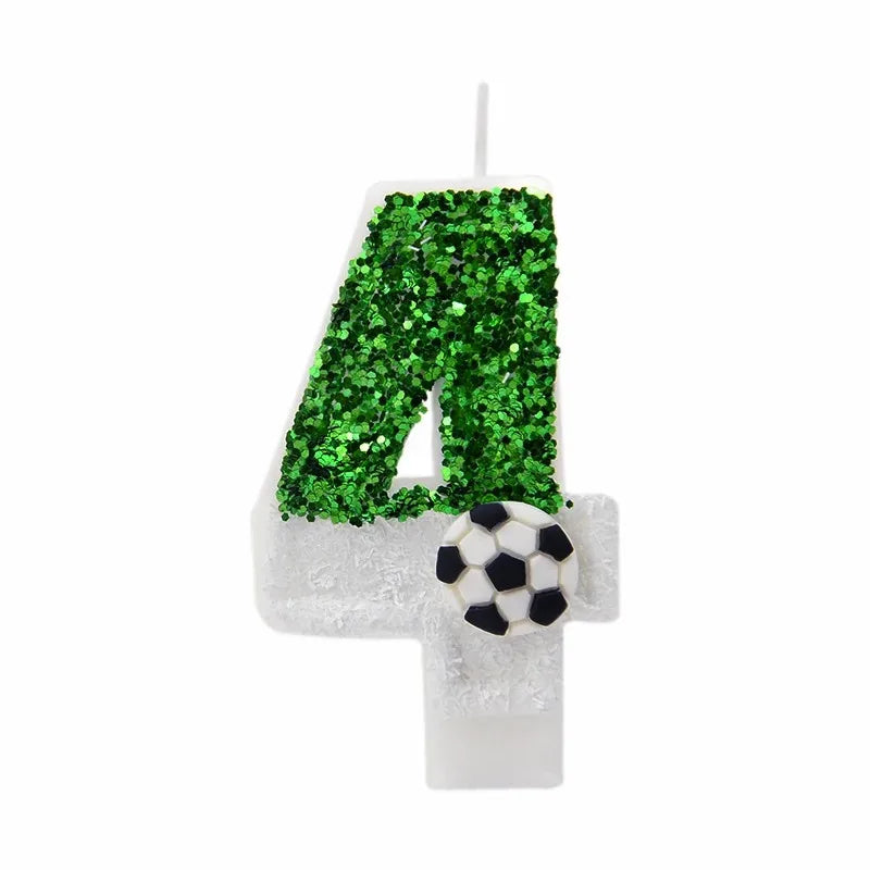 A white candle shaped like the number 4 covered in green glitter, with a soccer ball decoration.