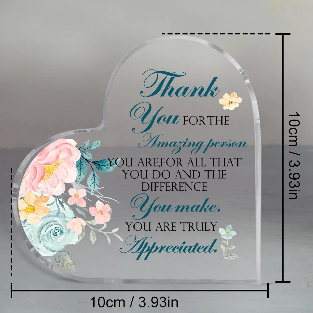 Clear acrylic heart-shaped sign with blue script text thanking someone for their amazing person and difference.