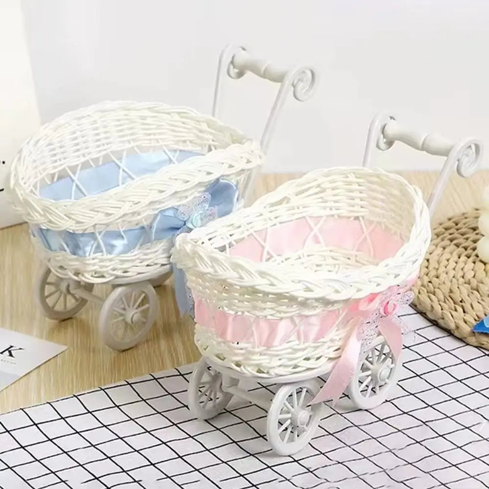 White faux rattan woven storage basket with handles and light blue ribbon accents on a black grid surface.