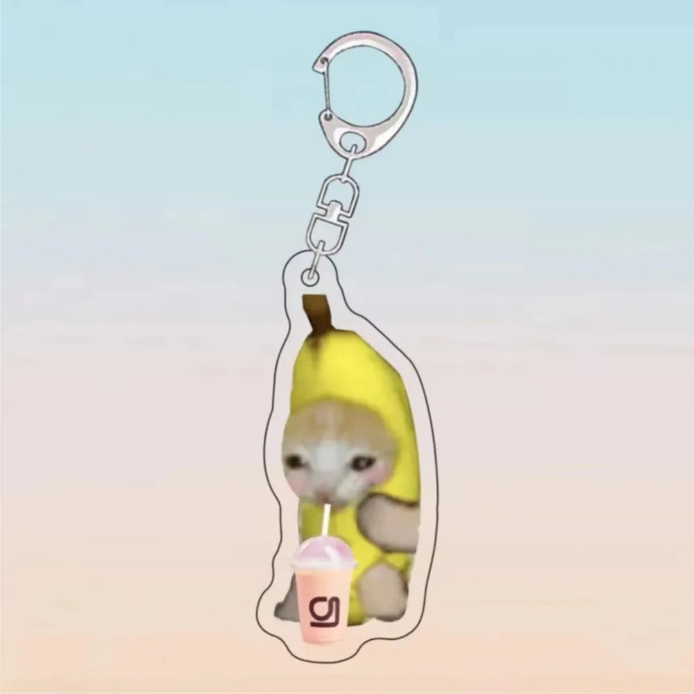 A yellow cat holding a pink ice cream cone charm on an acrylic keychain.