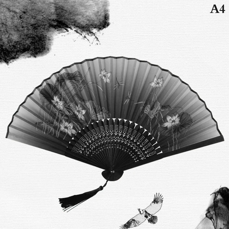 A black and white photograph of a hand carved bamboo folding fan with intricate patterns and a small bird flying below it.