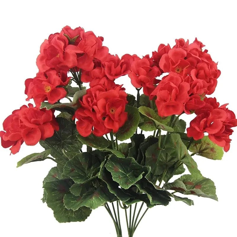 A bouquet of vibrant red faux silk geranium flowers with green leaves for outdoor and indoor decor.