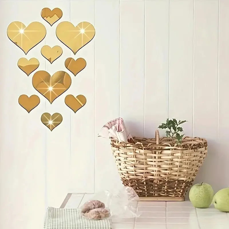 A set of gold heart-shaped mirror wall stickers displayed against a white paneled wall.