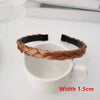 A brown braided hair band is shown resting on a white ceramic mug.
