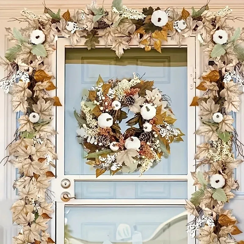 An artificial maple leaf vine garland wreath framed in white, featuring dried leaves and white berries for autumn decor.