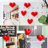 A set of red heart-shaped fridge magnets displayed against a white background with a blurred interior view.
