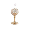 A golden crystal candle holder with a spherical glass top and pedestal base.