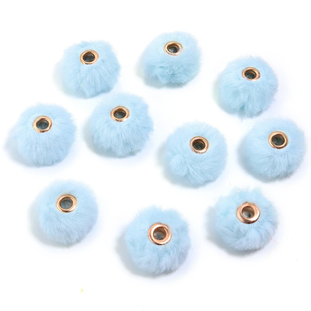 Collection de perles pompons bleues claires et duveteuses pour la fabrication de bijoux DIY.