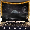 Dunkles Wandbild aus einem Wandteppich mit Vollmond über silhouettierten Bergen und funkelnden Lichterketten.