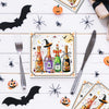 A flat lay of Halloween themed paper napkins featuring skeletons, spiders, and bats on a white wooden surface.