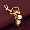 A gold-colored dice keychain with a lucky charm design attached to a split ring.