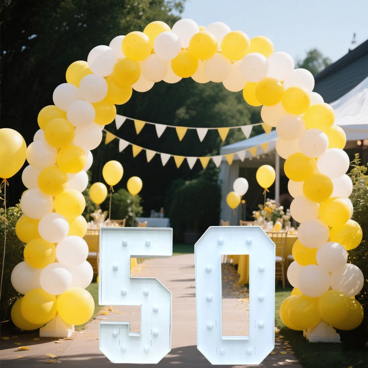 A large archway made of yellow and white balloons framing a marquee number sign that reads 50