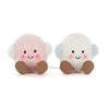 A pair of fluffy marshmallow plush toys, one pink and one white, with brown feet.
