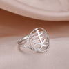 Silver signet ring featuring a Leviathan cross symbol on a light pink fabric background.