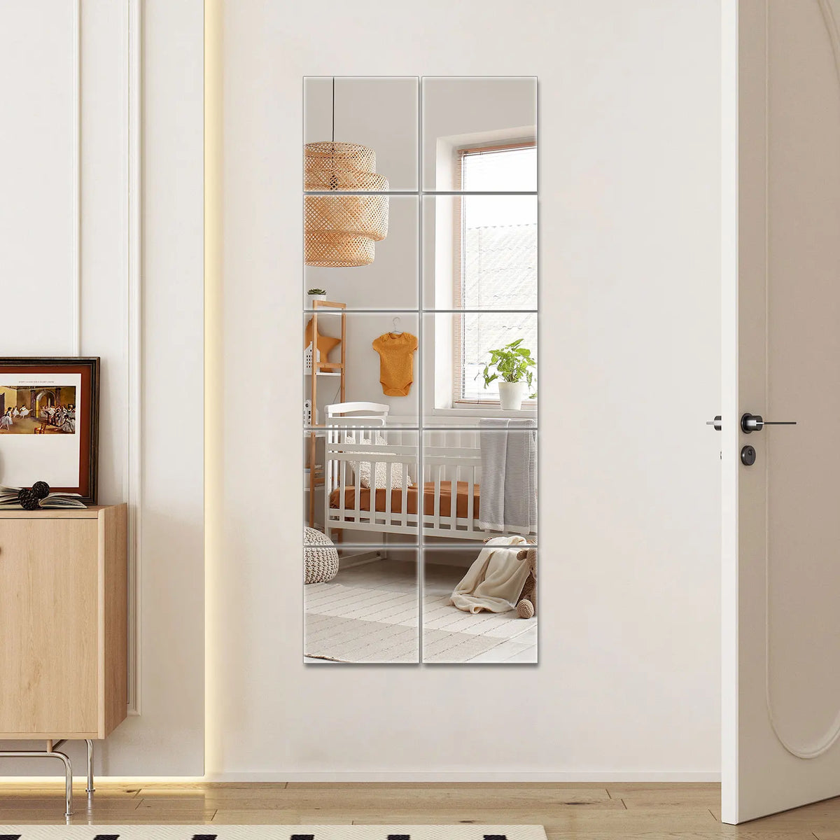 Un grand miroir rectangulaire reflète un intérieur de chambre de bébé avec meubles en bois et éléments décoratifs.