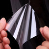 A hand is holding a clear, self-adhesive film that is being peeled back to show its layered structure.