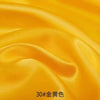 Close-up of flowing golden yellow satin fabric folds.