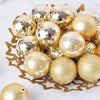 A collection of 24 gold and silver glitter Christmas tree ornament balls arranged on a gold star-shaped tray.