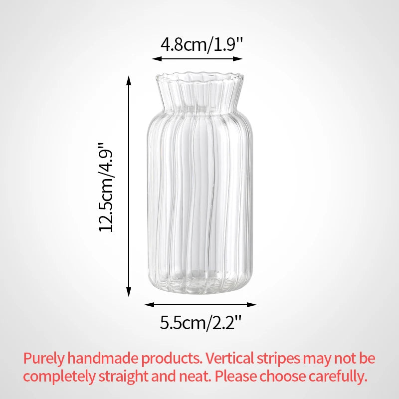 A tall, cylindrical clear glass vase with vertical ridges and a slightly flared rim.